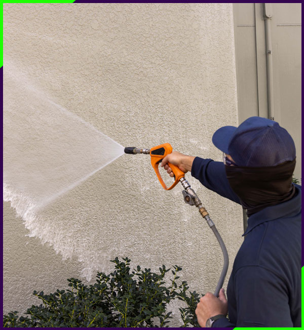 Exterior of a house being power washed by a professional