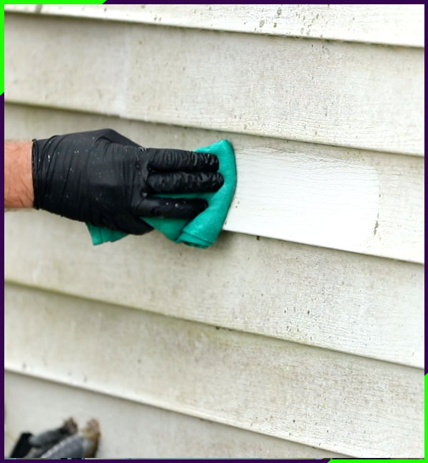 Cleaning siding with a towel to show dirt
